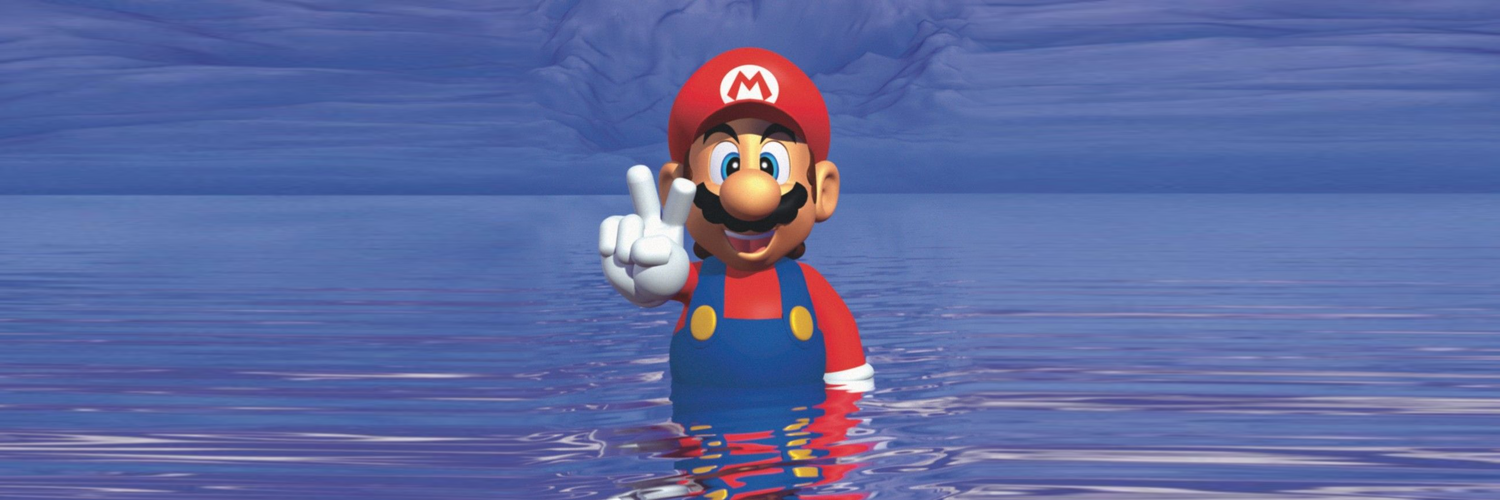 MARIO SEA standing in a calm blue ocean and making a peace sign